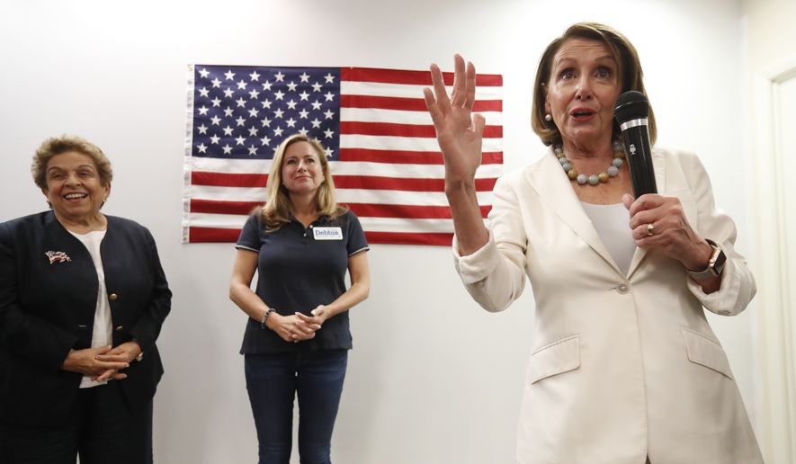 House Minority Leader Nancy Pelosi, right, speaks to volunteers at a get out the vote event for Florida Democratic congressional candidates Donna Shalala, left, and Debbie Mucarsel-Powell, center, Wednesday, Oct. 17, 2018, in Coral Gables, Fla. (AP Photo/Wilfredo Lee)