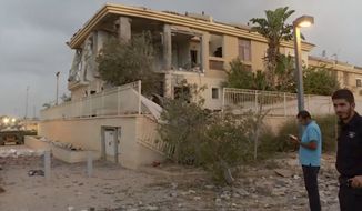 In this image made from video, police inspect the damage to a building from a rocket, Wednesday, Oct. 17, 2018, in Beersheba, Israel. The Israeli military says a rocket fired from Gaza made a direct hit on a home in southern Israel. Its the first rocket attack against Israel in months and the first that hit an Israeli home in Beersheba since the 2014 war between Israel and Gazas militant Hamas rulers. (KAN via AP)