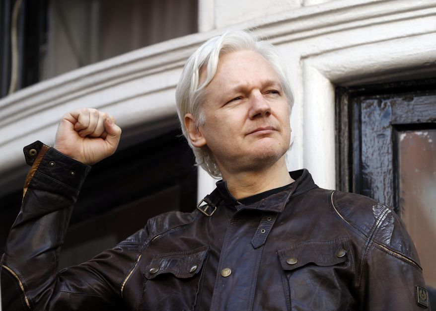 In this file photo dated Friday, May 19, 2017, WikiLeaks founder Julian Assange looks out from the balcony of the Ecuadorian Embassy in London. (AP Photo/Matt Dunham, FILE)