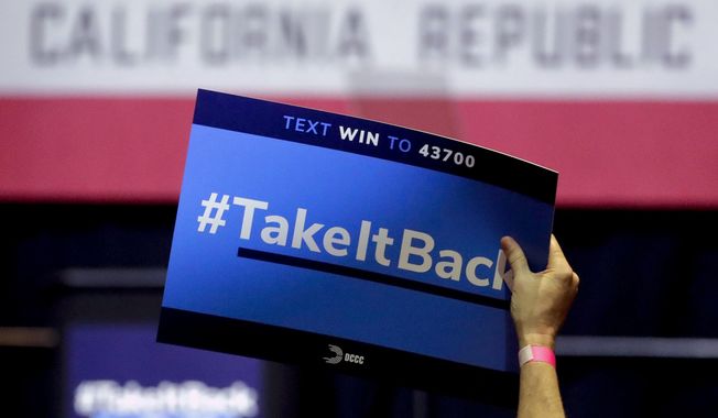 In this Thursday, Oct. 4, 2018, photo a supporter holds up a sign for Gil Cisneros, a candidate who is running for a U.S. House seat in the 39th District in California, at a rally on the Cal State Fullerton campus in Fullerton, Calif. For decades, Orange County, California, was known as a Republican stronghold but times have changed. A sign of the change is in the 39th District, where, Young Kim, a Korean immigrant Republican is running against Cisneros, a Hispanic Democrat. (AP Photo/Chris Carlson)