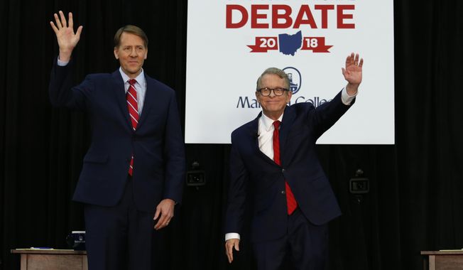 FILE - In this Monday, Oct. 1, 2018, file photo, Democratic gubernatorial candidate Richard Cordray, left, and Ohio Attorney General and Republican gubernatorial candidate Mike DeWine wave to the crowd before a debate at Marietta College in Marietta, Ohio. The two candidates are working to distinguish their positions and stave off critics from the far right and left to win Ohio&#x27;s high stakes governor&#x27;s race. (AP Photo/Paul Vernon, Pool, File)