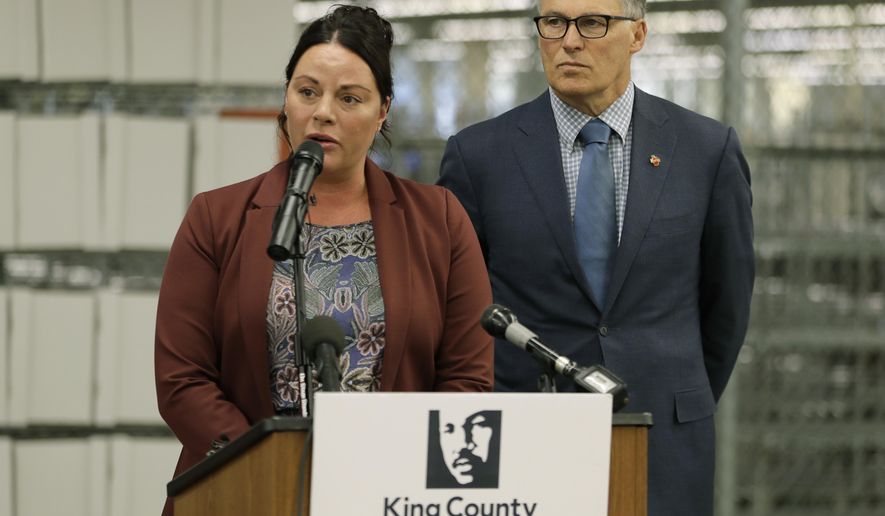 Washington Gov. Jay Inslee, right, looks on as King County Elections Director Julie Wise, left, talks to reporters about measures the state will take to insure secure voting in the upcoming November election, during a news conference, Tuesday, Oct. 16, 2018, in Renton, Wash. (AP Photo/Ted S. Warren)