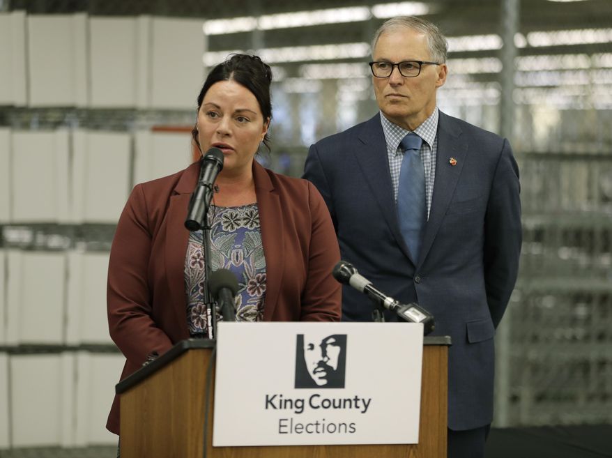 Washington Gov. Jay Inslee, right, looks on as King County Elections Director Julie Wise, left, talks to reporters about measures the state will take to insure secure voting in the upcoming November election, during a news conference, Tuesday, Oct. 16, 2018, in Renton, Wash. (AP Photo/Ted S. Warren)