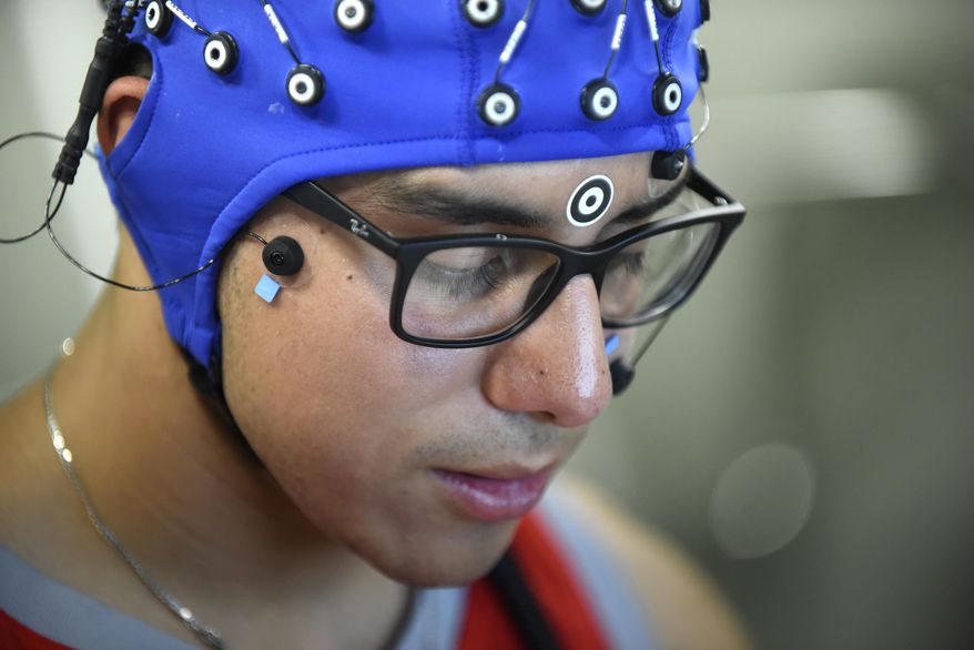 In this Sept. 21, 2018, photo, Jack Rodriguez, a student at Texas State University and has been a stutterer all of his life participates in a study at UTSA that uses electrodes on his head to pick up signals to graph what his brain is doing when he is speaking fluently and not in Texas. (Billy Calzada/The San Antonio Express-News via AP)