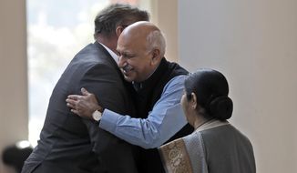 FILE - In this Nov. 24, 2017 file photo, Indian Junior Foreign Minister M.J. Akbar, center, hugs Finland&#39;s Foreign Minister Timo Soini in New Delhi, India. Akbar has resigned amid accusations by at least 15 women of sexual harassment during his previous career as a news editor. (AP Photo/Manish Swarup, File)