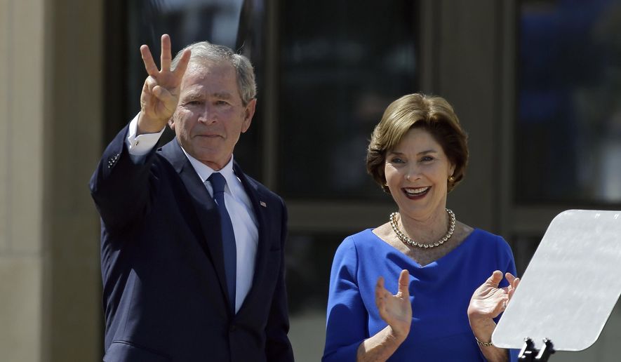In this April 25, 2013, file photo, former President George W. Bush, accompanied by his wife, former first lady Laura Bush, flashes the "W" sign after his speech during the dedication of the George W. Bush Presidential Center in Dallas. (AP Photo/David J. Phillip, File)