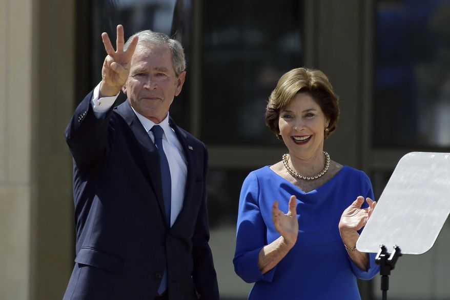 In this April 25, 2013, file photo, former President George W. Bush, accompanied by his wife, former first lady Laura Bush, flashes the "W" sign after his speech during the dedication of the George W. Bush Presidential Center in Dallas. (AP Photo/David J. Phillip, File)