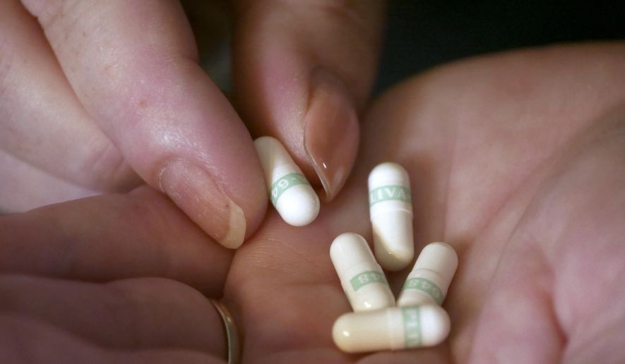 In this July 11, 2018, photo Bridgett Snelten holds her medication at her home, in Sandy, Utah. Snelten has diabetes and has had to change health insurance plans three years in a row. (AP Photo/Rick Bowmer)