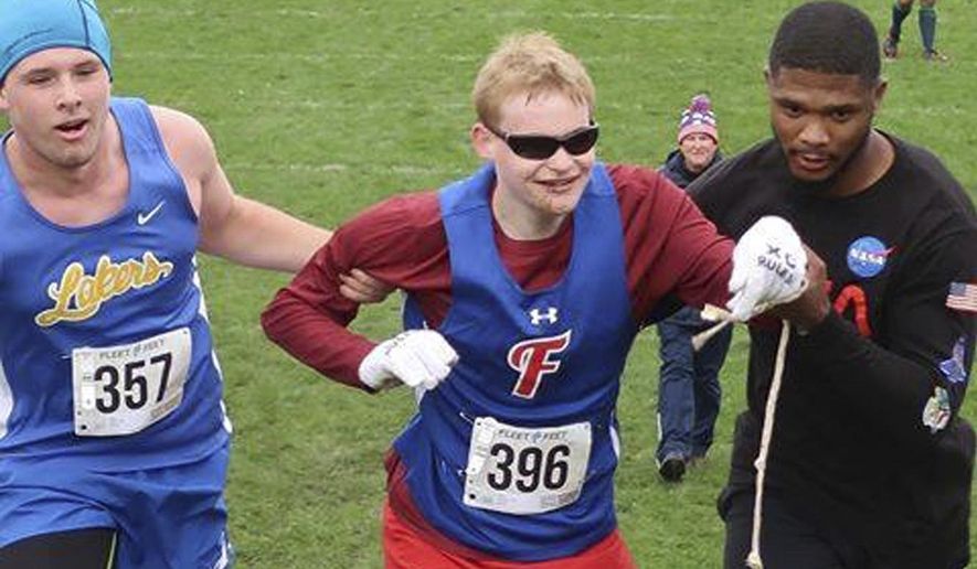 In this Saturday, Oct. 13, 2018 photo provided by Karen Wylie, Cazenovia High School sophomore Jake Tobin, left, helps Fairport High School senior Luke Fortner, center, during a cross country race in Auburn, N.Y. Fortner, who is legally blind, fell towards the end of the race but was assisted by Tobin, and Jerry Thompson, right, his running aide. The three then crossed the finish line together. (Karen Wylie via AP)
