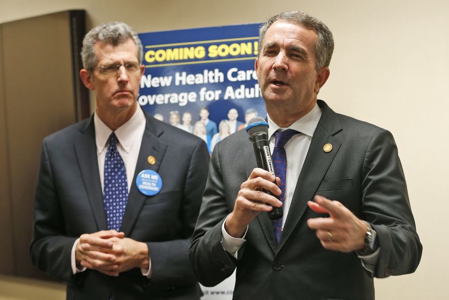 Virginia Gov. Ralph Northam, right, gestures during a press conference along with Virginia Secretary of Health, Daniel Carey, in Richmond, Va., Thursday, Oct. 18, 2018. Northam announced a key approval in the medicaid expansion process that will allow Virginia to begin accepting applications for expanded health coverage. (AP Photo/Steve Helber)