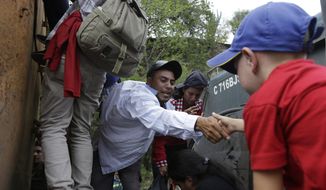 Honduran migrants walking to the U.S. climb on to the space between the cab and bed of a trailer in Zacapa, Guatemala, Wednesday, Oct. 17, 2018. The group of some 2,000 Honduran migrants hit the road in Guatemala again Wednesday, hoping to reach the United States despite President Donald Trump&#39;s threat to cut off aid to Central American countries that don&#39;t stop them. (AP Photo/Moises Castillo)