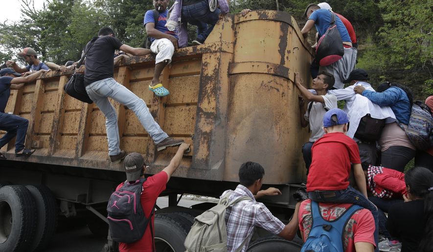 Honduran migrants bound to the U.S border climb into the bed of a truck in Zacapa, Guatemala, Wednesday, Oct. 17, 2018. The group of some 2,000 Honduran migrants hit the road in Guatemala again Wednesday, hoping to reach the United States despite President Donald Trump's threat to cut off aid to Central American countries that don't stop them. (AP Photo/Moises Castillo)