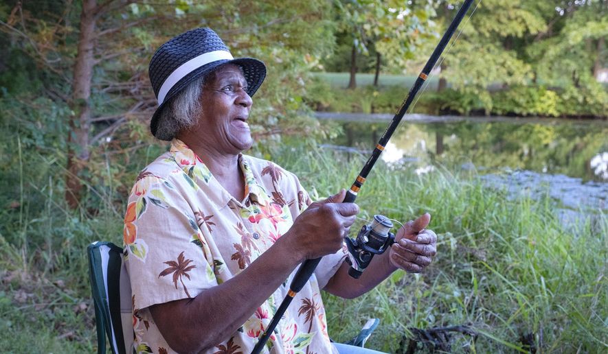 In this Oct. 1, 2018 file photo, Georgia Doss fishes for bluegill at Campus Lake on the Southern Illinois University campus on in Carbondale, Ill. In the fall of 2016 and the spring of 2017, the university spent some $450,000 to drain six to eight feet of water from the lake, and clear the trash and debris from the shoreline and the shallows. Community volunteers pitched in to collect the junk and haul it away. Now that the work is completed, Campus Lake is back to being Southern Illinois' best-kept-secret fishing hole. (Byron Hetzler/The Southern, via AP)