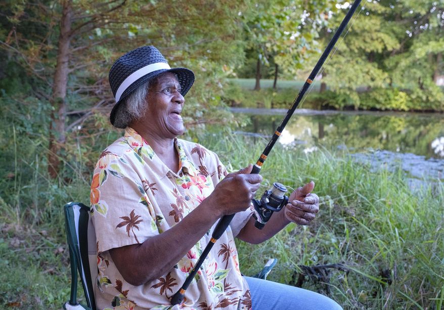In this Oct. 1, 2018 file photo, Georgia Doss fishes for bluegill at Campus Lake on the Southern Illinois University campus on in Carbondale, Ill. In the fall of 2016 and the spring of 2017, the university spent some $450,000 to drain six to eight feet of water from the lake, and clear the trash and debris from the shoreline and the shallows. Community volunteers pitched in to collect the junk and haul it away. Now that the work is completed, Campus Lake is back to being Southern Illinois' best-kept-secret fishing hole. (Byron Hetzler/The Southern, via AP)