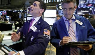 FILE- In this Oct. 11, 2018, file photo trader Peter Mazza, left, works with trader Daniel Trimble on the floor of the New York Stock Exchange. The U.S. stock market opens at 9:30 a.m. EDT on Thursday, Oct. 18. (AP Photo/Richard Drew, File)