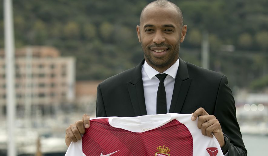 New AS Monaco head coach Thierry Henry holds up his club jersey during his official media presentation at the Monaco Yacht Club, Wednesday, Oct. 17, 2018. France&#39;s all-time leading scorer and an Arsenal great landed his first managerial job on Saturday after Monaco hired him as a replacement for Leonardo Jardim, who was dismissed this week. (AP Photo/Olivier Anrigo)