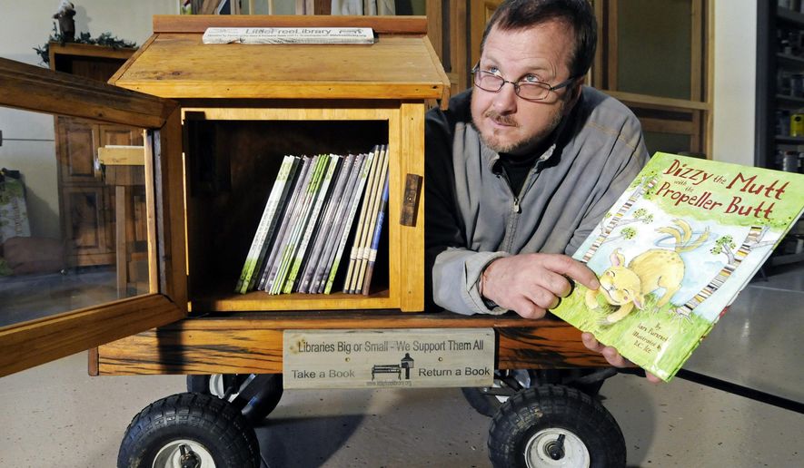 FILE - In this Dec. 6, 2012 file photo, Todd Bol poses with a Little Free Library lending boxes in Hudson, Wis. Bol, who founded Little Free Library, the boxes of books for sharing that popped up across the U.S. and spread to more than 80 countries, died Thursday, Oct. 18, 2018, in a Minnesota hospice of complications from pancreatic cancer, according to Little Free Library spokeswoman Margret Aldrich. He was 62. (AP Photo/Jim Mone, File)