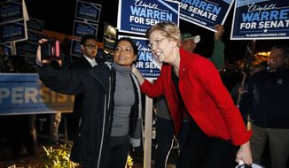 Sen. Elizabeth Warren poses for a selfie while greeting supporters before a debate with her Republican opponent Geoff Diehl in Boston, Friday, Oct. 19, 2018. (AP Photo/Michael Dwyer)