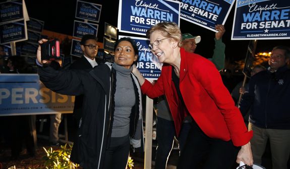 Sen. Elizabeth Warren poses for a selfie while greeting supporters before a debate with her Republican opponent Geoff Diehl in Boston, Friday, Oct. 19, 2018. (AP Photo/Michael Dwyer)