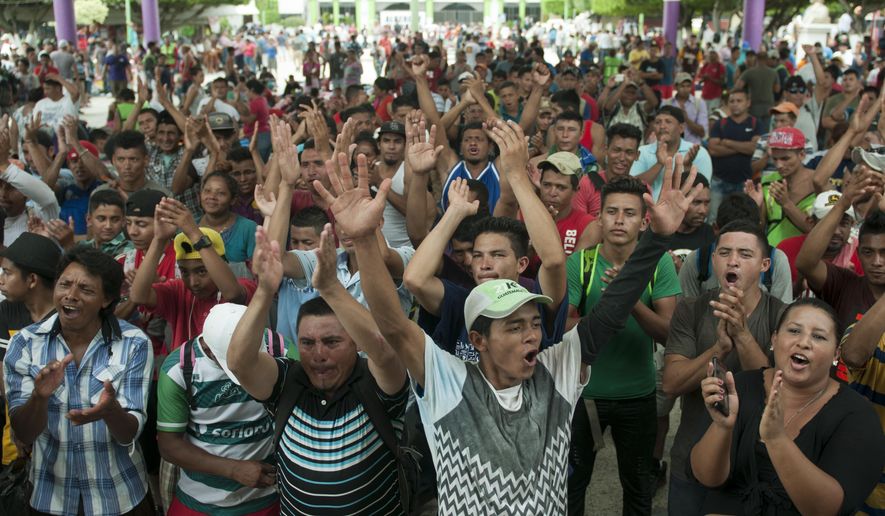 A group of Central American migrants gather in the central park of Ciudad Hidlago, Mexico, Saturday, Oct. 20, 2018. Mexican authorities for a second straight day refused mass entry to a caravan of Central American migrants held up at the border with Guatemala, but began accepting small groups for asylum processing and gave out some 45-day visitor permits that would theoretically allow recipients time to reach the United States. (AP Photo/Oliver de Ros)