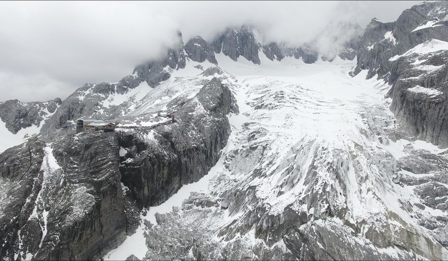 In this photo taken May 2018 and released by Yulong Snow Mountain Glacier and Environmental Observation Research Station on Oct. 18, 2018, the Baishui Glacier No.1 is visible next to a tourist viewing platform high in the Jade Dragon Snow Mountain in the southern province of Yunnan in China. Scientists say the glacier is one of the fastest melting glaciers in the world due to climate change and its relative proximity to the Equator. It has lost 60 percent of its mass and shrunk 250 meters since 1982. (Yulong Snow Mountain Glacier and Environmental Observation Research Station via AP)