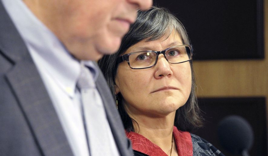 FILE - In this Oct. 16, 2018, file photo, Alaska&#x27;s new Lt. Gov. Valerie Davidson, right, looks on as Gov. Bill Walker addresses a news conference in Anchorage, Alaska. Davidson, the state&#x27;s new lieutenant governor and the first Alaska Native woman to hold higher office in Alaska, has fought for Alaska Native social issues for decades. Now 51, the Yup&#x27;ik from Southwest Alaska was an 18-year-old college student when she made national headlines in 1985. (AP Photo/Mark Thiessen, File )