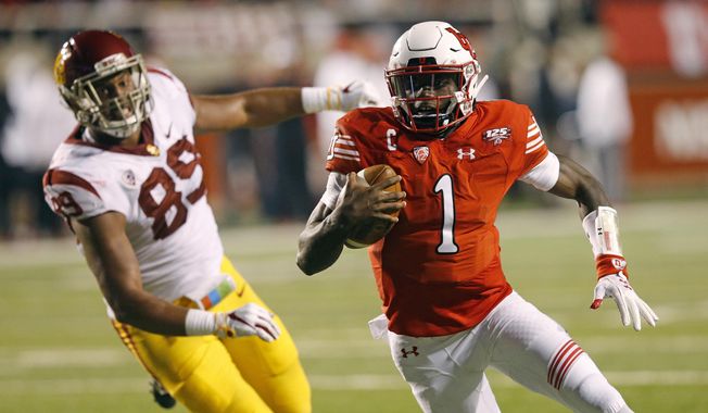 Utah quarterback Tyler Huntley (1) carries the ball in for a touchdown as Southern California defensive lineman Christian Rector (89) pursues during the first half of an NCAA college football game Saturday, Oct. 20, 2018, in Salt Lake City. (AP Photo/Rick Bowmer)