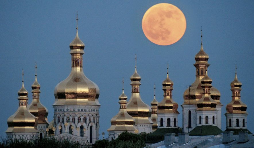 In this May 4, 2004, photo, a full moon rises above the golden domes of the Orthodox Monastery of the Caves in Kiev, Ukraine. Tensions over the imminent formation of a Ukrainian Orthodox church independent of Moscow are raising fears that nationalists will try to seize Russian church properties.(AP Photo/Efrem Lukatsky, File)