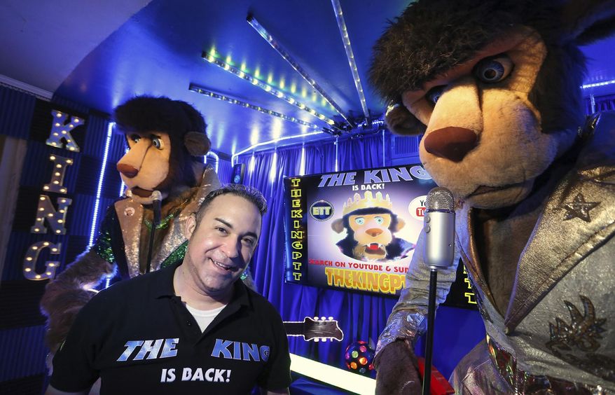 Jared Sanchez, center, poses with The King, left, and King Puff, right, in his Tampa home Monday, Sept. 17, 2018. Sanchez is so obsessed with the 10-foot tall animatronic lions that sang Elvis tunes in Chuck E. Cheese's restaurants, he now owns four. 'I don't hoard, I restore,' he said jokingly during a recent tour. Sanchez converted a master bedroom of his home into a studio and now films the lions singing parody songs and posts them to YouTube. (James Borchuck/Tampa Bay Times via AP)