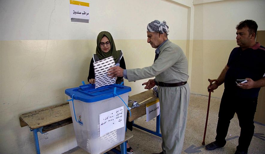 FILE - In this Sept. 30, 2018 file photo, an Iraqi Kurd casts his ballot during parliamentary elections in Irbil, Iraq. The government of Iraq's autonomous Kurdish region said Sunday, Oct. 21, 2018, that the party that led the region into its ill-fated independence referendum last year has won the most seats in regional parliamentary elections. The elections commission says the Kurdistan Democratic Party won 45 seats, 12 seats short of an outright majority in the 111-seat body. (AP Photo/Salar Salim, File)