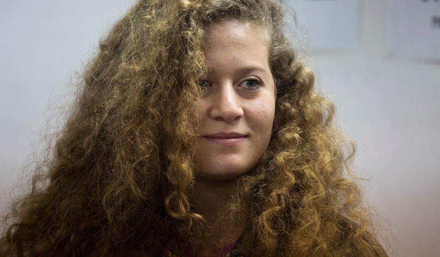 FILE - In this Tuesday, Feb. 13, 2018 file photo, Palestinian activist Ahed Tamimi stands inside the Ofer military prison near Jerusalem. When Israel locked up Ahed Tamimi for slapping a soldier last year, it hoped to finally silence the teenage Palestinian activist. Instead, it created an international celebrity. (AP Photo/Ariel Schalit, File)