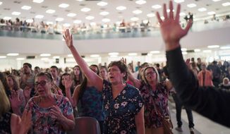 In this Sept. 2, 2018, file photo, evangelicals raise their hands in prayer as they listen to a song during a service at the Assembly of God Victory in Christ Church in Rio de Janeiro, Brazil.  (AP Photo/Leo Correa) **FILE**