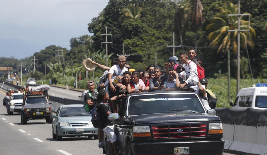 Central American migrants making their way to the U.S. in a large caravan fill the truck of a driver who offered them the free ride, as they arrive to Tapachula, Mexico, Sunday, Oct. 21, 2018. Despite Mexican efforts to stop them at the Guatemala-Mexico border, about 5,000 Central American migrants resumed their advance toward the U.S. border Sunday in southern Mexico. (AP Photo/Moises Castillo)