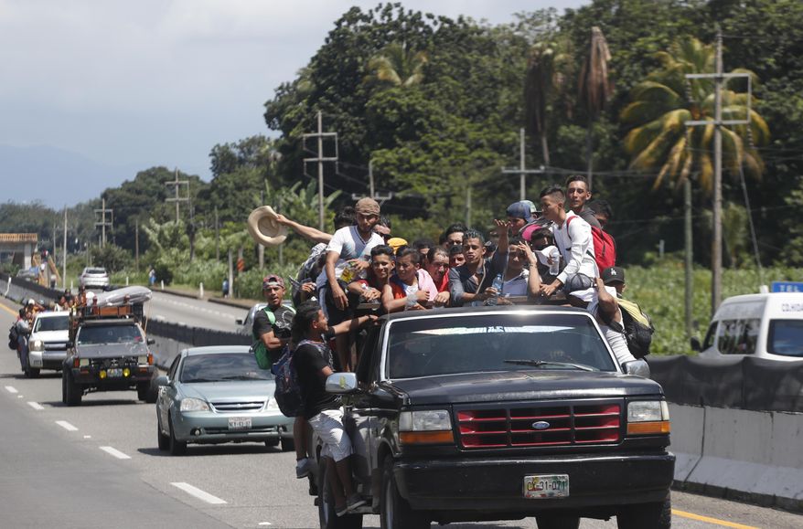 Central American migrants making their way to the U.S. in a large caravan fill the truck of a driver who offered them the free ride, as they arrive to Tapachula, Mexico, Sunday, Oct. 21, 2018. Despite Mexican efforts to stop them at the Guatemala-Mexico border, about 5,000 Central American migrants resumed their advance toward the U.S. border Sunday in southern Mexico. (AP Photo/Moises Castillo)