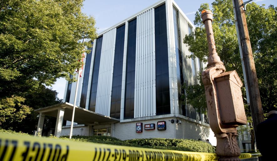 Police respond after a man was shot by a security guard while trying to break into the lobby of a building housing the offices of WTTG-TV, the local Fox broadcast affiliate in Washington, Monday, Oct. 22, 2018. (AP Photo/Andrew Harnik)