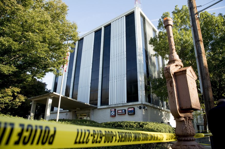 Police respond after a man was shot by a security guard while trying to break into the lobby of a building housing the offices of WTTG-TV, the local Fox broadcast affiliate in Washington, Monday, Oct. 22, 2018. (AP Photo/Andrew Harnik)