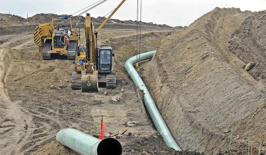 FILE - In this Oct. 5, 2016, file photo, heavy equipment is seen at a site where sections of the Dakota Access pipeline were being buried near the town of St. Anthony in Morton County, N.D. On Friday, Oct. 19, 2018, Texas-based Energy Transfer Partners, the developer of the pipeline, began seeking commitments from shippers to transport additional oil through the pipeline from 500,000 barrels to 570,000 barrels per day, despite ongoing tribal efforts to shut the pipeline down. (Tom Stromme/The Bismarck Tribune via AP, File)