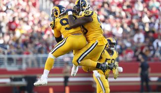 Los Angeles Rams defensive tackle Aaron Donald, left, celebrates with defensive tackle Michael Brockers (90) during the second half of an NFL football game against the San Francisco 49ers in Santa Clara, Calif., Sunday, Oct. 21, 2018. (AP Photo/Tony Avelar)