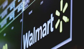 In this May 17, 2018, file photo, the logo for Walmart appears above a trading post on the floor of the New York Stock Exchange. Walmart Inc. is making two improvements to its third-party marketplace heading into the holidays as it seeks to better compete with online leader Amazon.com. (AP Photo/Richard Drew, File)