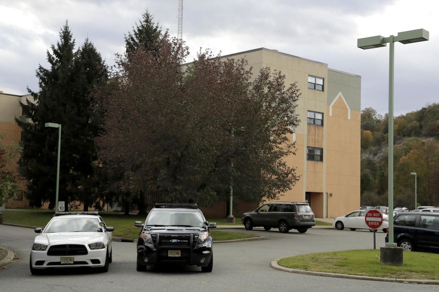 Police cruisers are seen parked near the entrance of the Wanaque Center For Nursing And Rehabilitation, where New Jersey state Health Department confirmed the 18 cases of adenovirus, Tuesday, Oct. 23, 2018, in Haskell, N.J. The outbreak has left six children dead and 12 others sick. The facility has been told it can't admit any new patients until the outbreak ends. Adenoviruses usually just cause mild illnesses. But officials say this outbreak is particularly severe because it's affecting medically fragile children with severely compromised immune systems. They also note this strain has been particularly associated with disease in communal living facilities. (AP Photo/Julio Cortez)