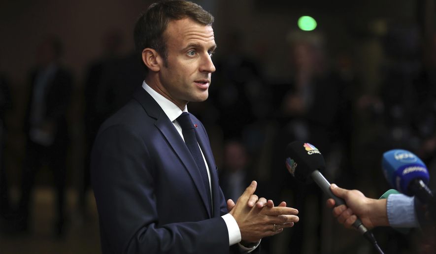 FILE - In this Wednesday, Oct. 17, 2018 file photo, French President Emmanuel Macron speaks with the press as he arrives for an EU summit in Brussels. France’s Presidential Press Association has called on President Emmanuel Macron to reconsider his decision to close the press room inside the presidential palace. In a statement Tuesday, Oct, 23 the association that represents French and foreign media accredited with the presidency said the press room’s closure would be “a lockdown of the Elysee Palace and a decision prejudicial to journalists’ freedom to inform and to work.” (AP Photo/Francisco Seco, file)