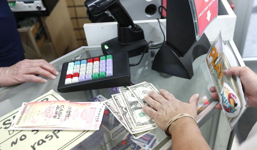 A customer purchases lottery tickets, Monday, Oct. 22, 2018, at La Preferida Superdiscount store in Hialeah, Fla., in this file photo. (AP Photo/Wilfredo Lee) **FILE**