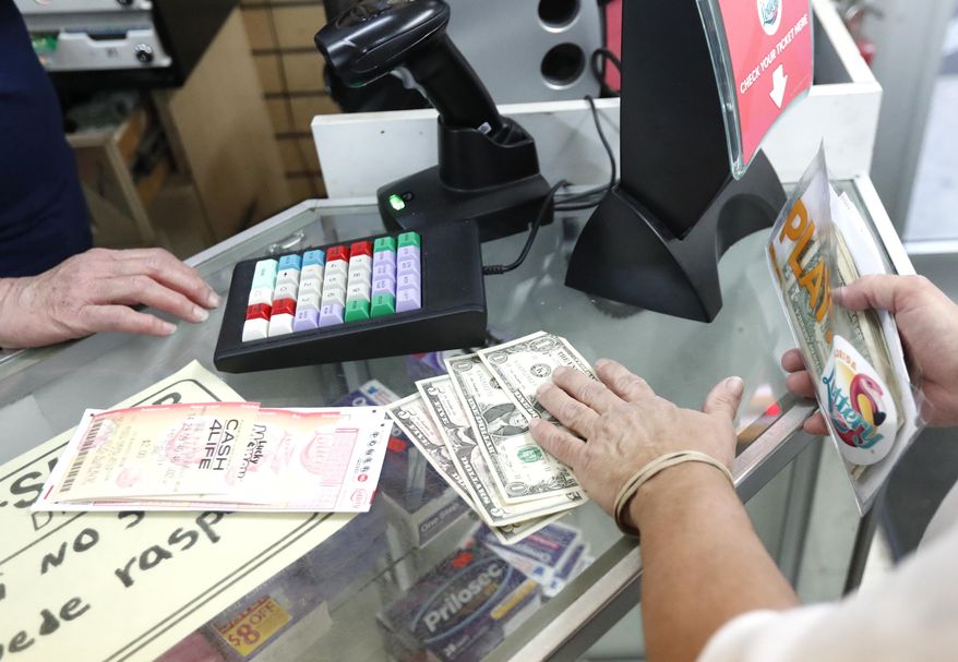 A customer purchases lottery tickets, Monday, Oct. 22, 2018, at La Preferida Superdiscount store in Hialeah, Fla., in this file photo. (AP Photo/Wilfredo Lee) **FILE**
