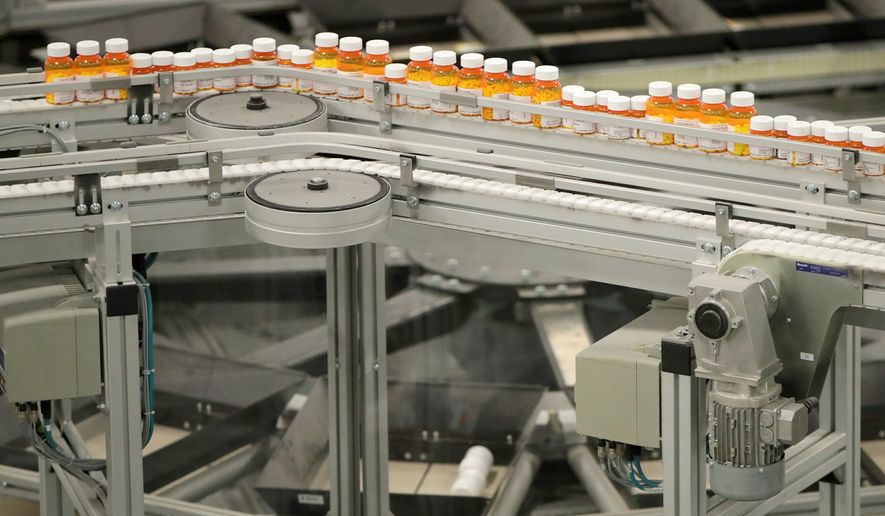 In this July 10, 2018, file photo bottles of medicine ride on a belt at the Express Scripts mail-in pharmacy warehouse in Florence, N.J. On Monday, Oct. 15, the industry&#39;s largest trade group announced that dozens of drugmakers will start disclosing the prices for U.S. prescription drugs advertised on TV. The prices won&#39;t actually be shown in the TV commercials but the advertisement will include a website where the list price will be posted. (AP Photo/Julio Cortez, File)