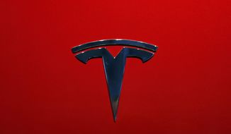 FILE- This Oct. 3, 2018, file photo shows the logo of Tesla model 3 at the Auto show in Paris. Tesla Inc. reports earnings on Wednesday, Oct. 24. (AP Photo/Christophe Ena, File)
