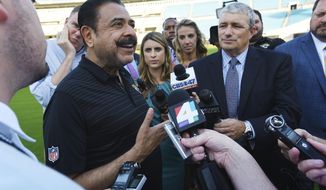 FILE - In this Thursday, April 26, 2018, file photo, Jacksonville Jaguars owner Shad Khan, left, fields questions from the media on his interest in buying Wembley Stadium in London ahead of the Uniform Launch and Draft Party NFL football event at EverBank Field in Jacksonville, Fla. Khan tried to strengthen the franchise’s foothold in London by bidding $790 million (£600 million) on Wembley Stadium in April. He withdrew his offer for the English Football Association’s main asset in October 2018 after recognizing the extent of opposition to the sale. (Bob Self/The Florida Times-Union via AP, File)