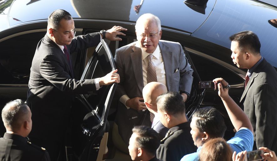 Former Malaysian Prime Minister Najib Razak gets off a car upon arrival at Kuala Lumpur High Court in Kuala Lumpur, Malaysia, Thursday, Oct. 25, 2018. Najib, along with two former high-ranking officials, faces fresh charges of criminal breach of trust involving the use of government funds. (AP Photo/Yam G-Jun)