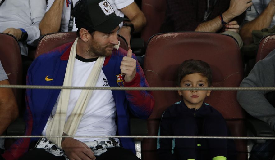 Barcelona forward Lionel Messi sits in the stands prior to ...