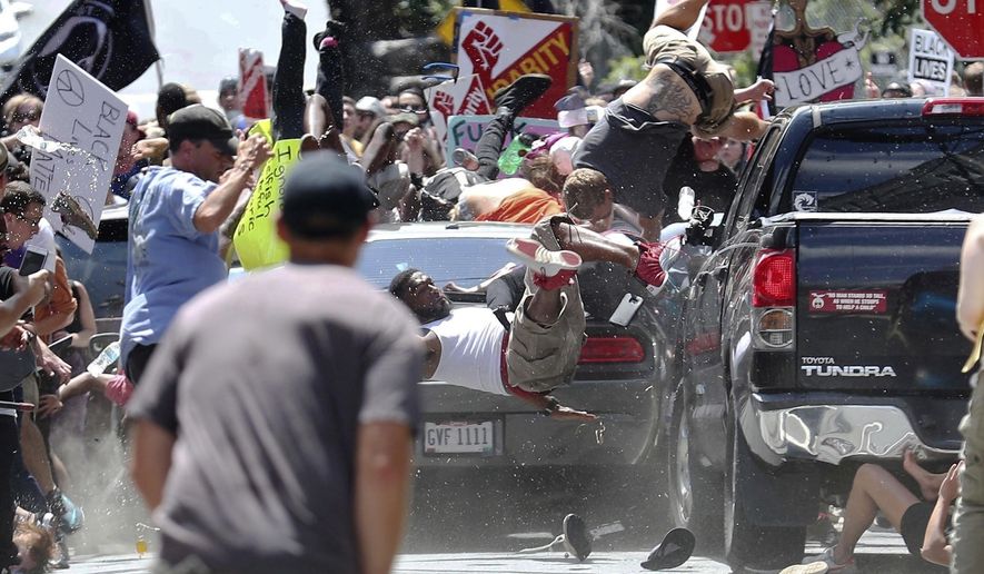 In this Aug. 12, 2017, file photo, people fly into the air as a vehicle drives into a group of protesters demonstrating against a white nationalist rally in Charlottesville, Va. (Ryan M. Kelly/The Daily Progress via AP, File)/The Daily Progress via AP)