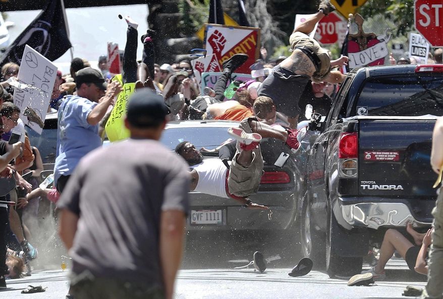 In this Aug. 12, 2017, file photo, people fly into the air as a vehicle drives into a group of protesters demonstrating against a white nationalist rally in Charlottesville, Va. (Ryan M. Kelly/The Daily Progress via AP, File)/The Daily Progress via AP)